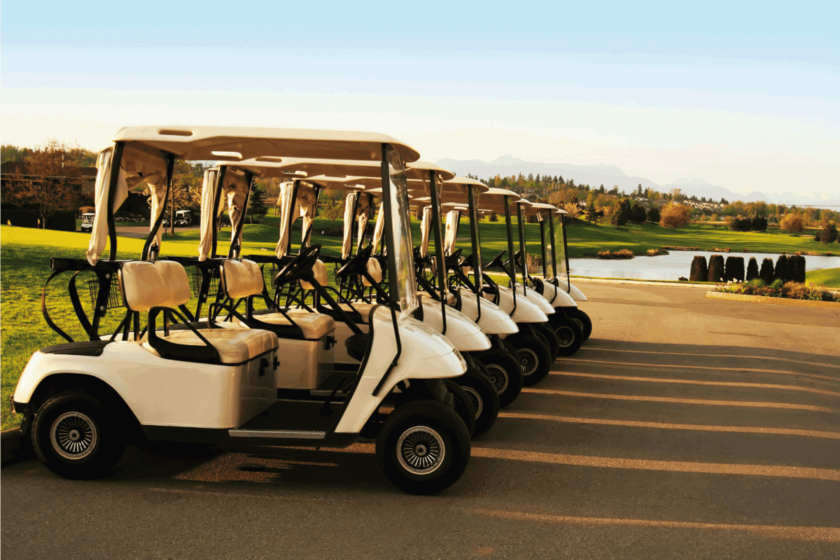 Yamaha golf carts neatly lined up on the side of a concrete roadway