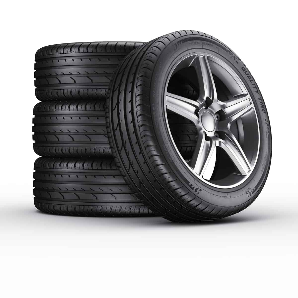 four car tires stacked against a white background
