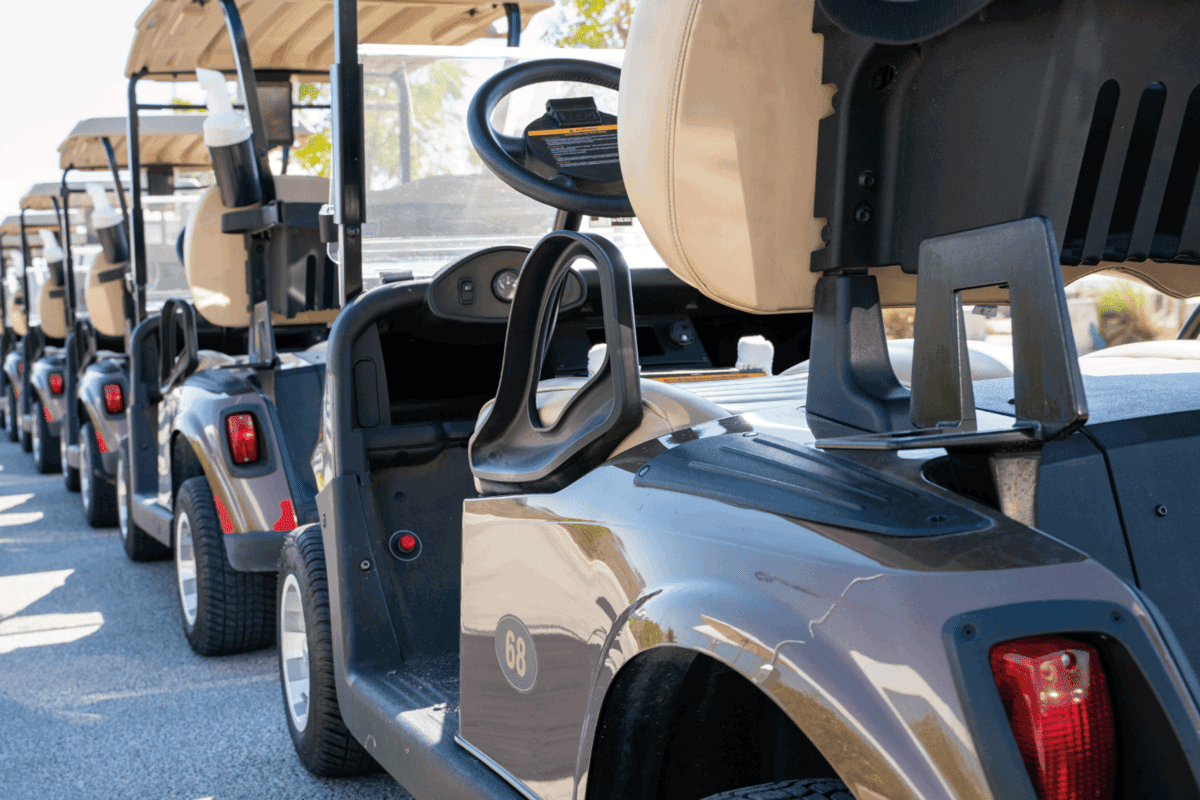 image of multiple golf carts parked in order.
