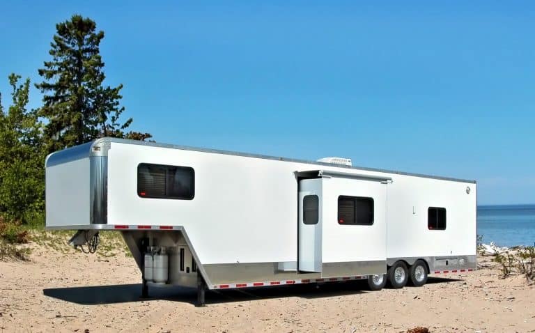large white toy hauler sitting in a camping spot