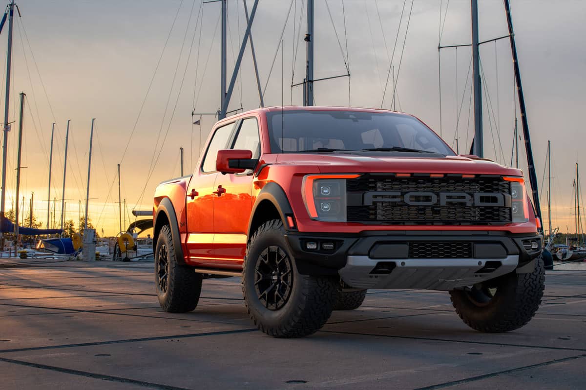 A big red colored Ford F-150 Raptor parked near a dock, How To Drain The Fuel Tank Of A Ford F-150