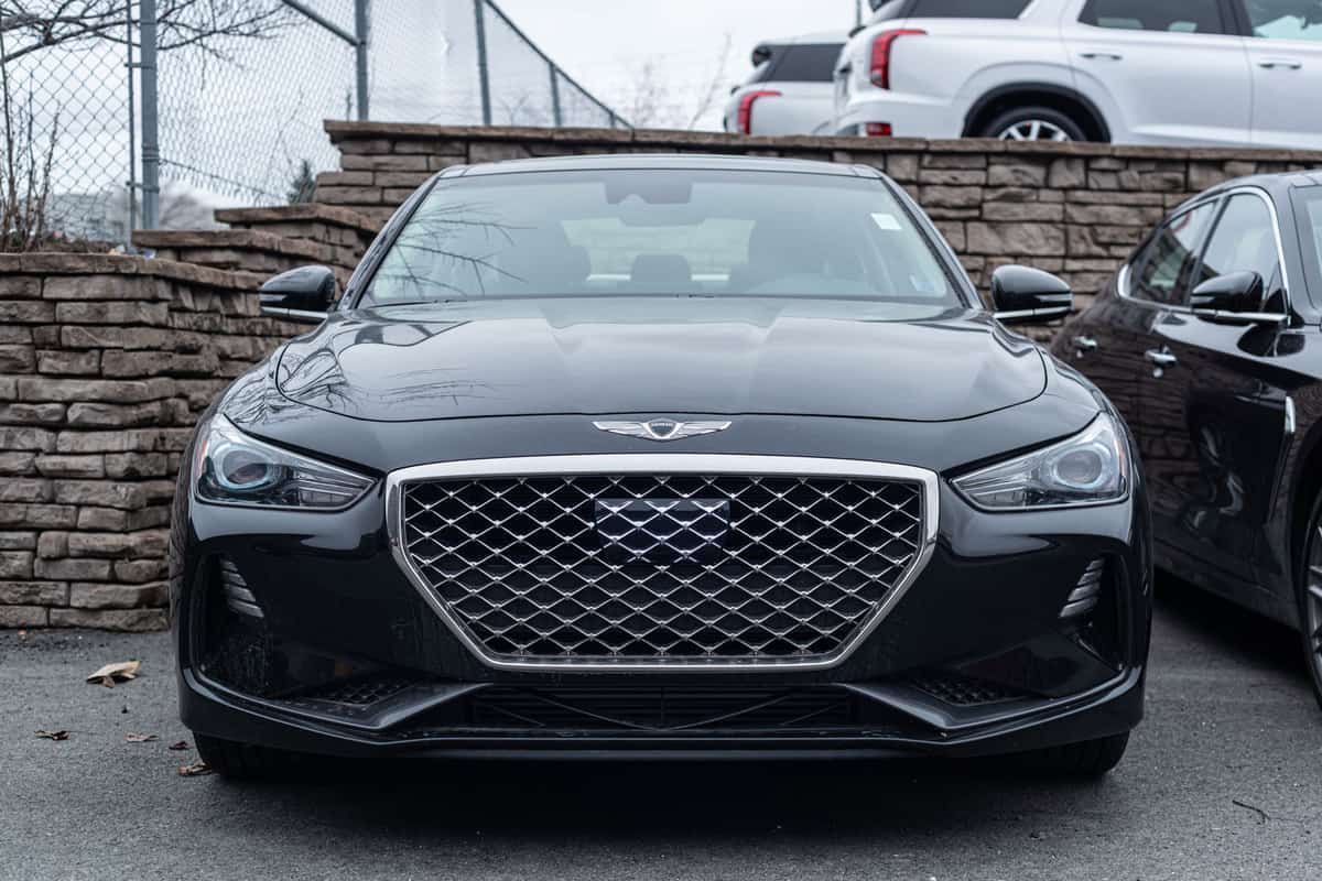 A black and luxurious Genesis G70 photographed on the parking lot