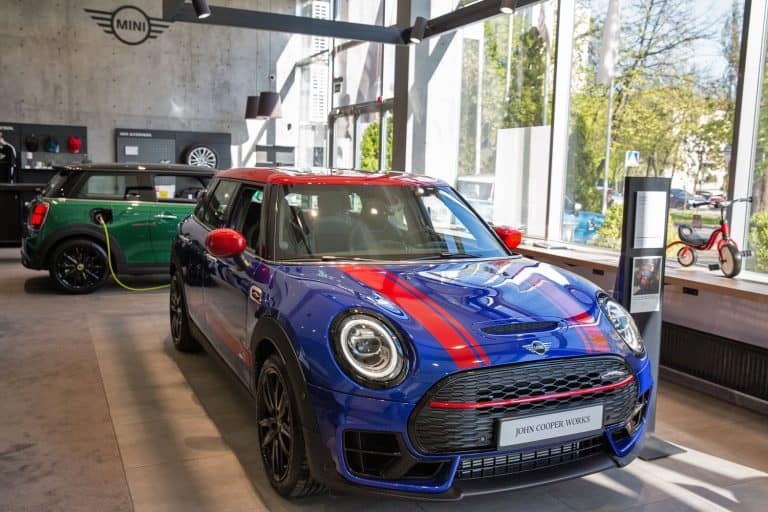 A blue and red striped Mini Clubman displayed at a dealership, Can You Fit A Towbar To A Mini Clubman?