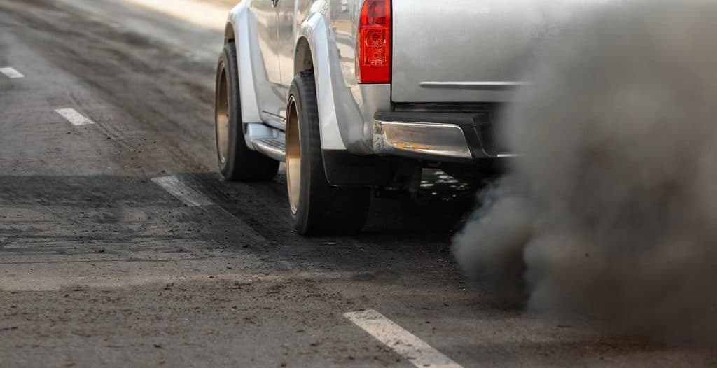 Air pollution crisis in city from diesel vehicle exhaust pipe on road