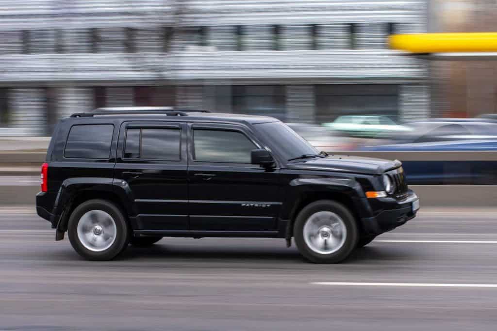 Black Jeep Patriot car moving on the street