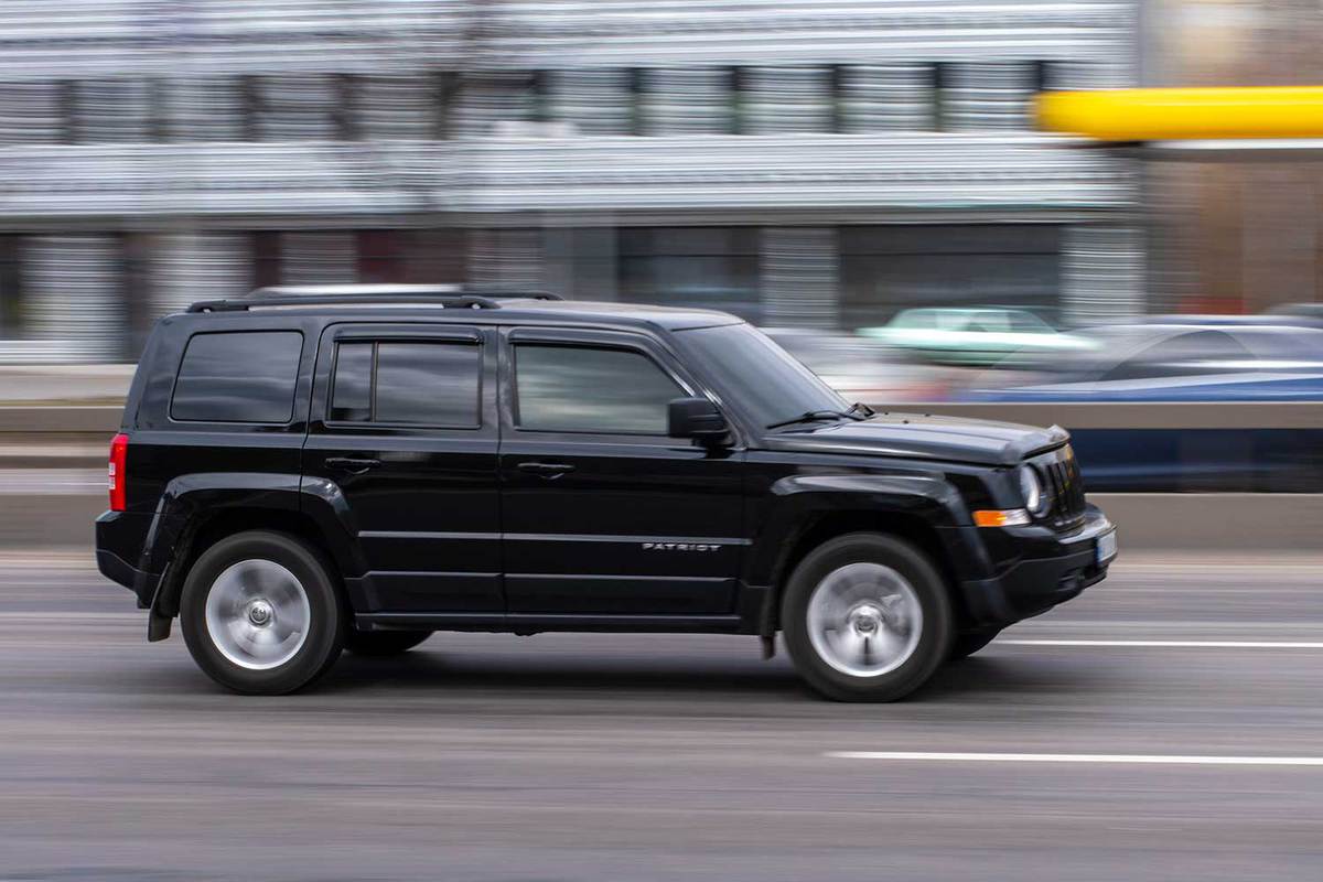 Black Jeep Patriot car moving on the street
