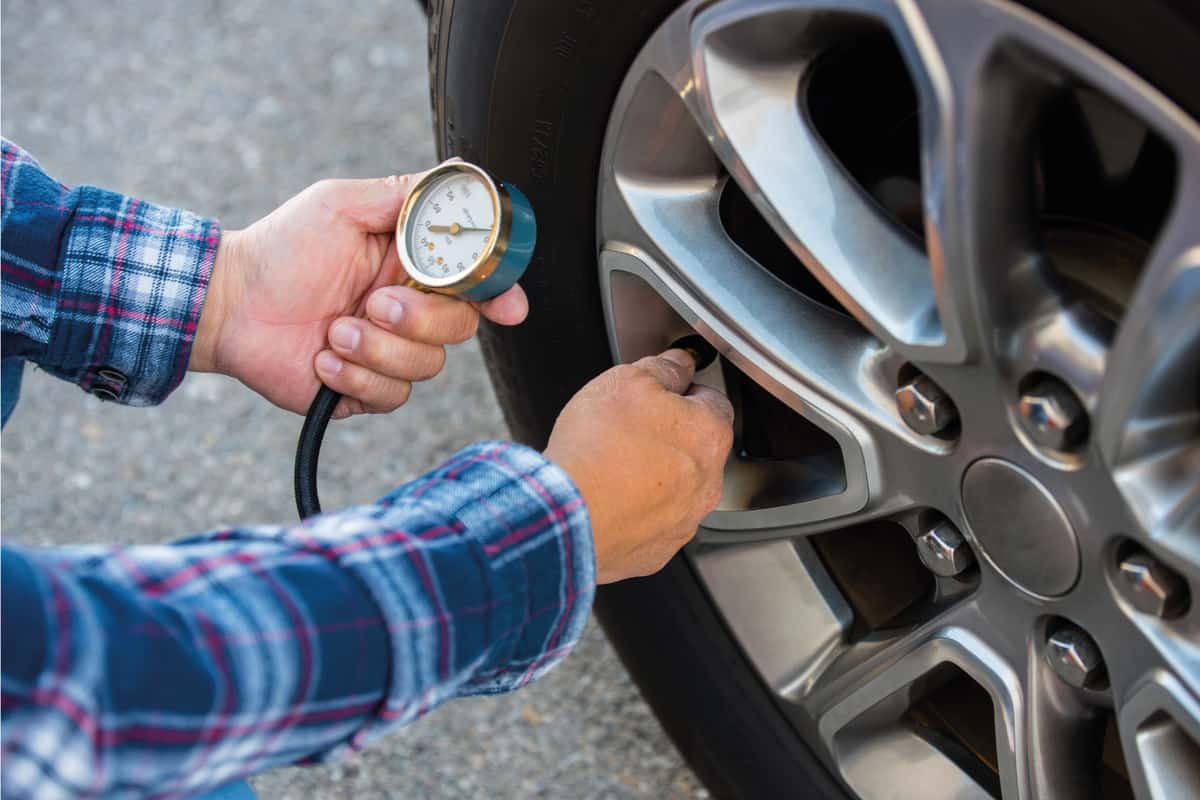 Checking tire pressure with pressure gauge