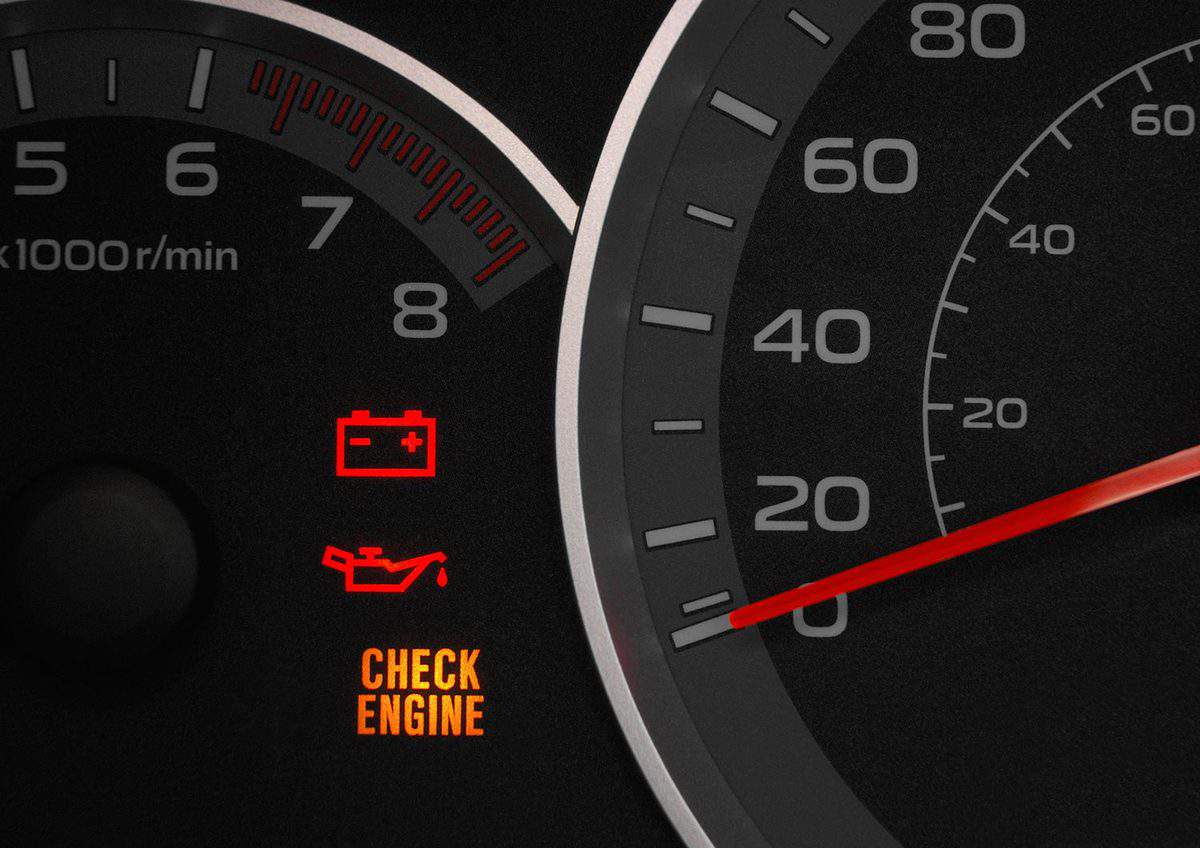 Close up on a cluster with the check engine warning light on indicating a car failure