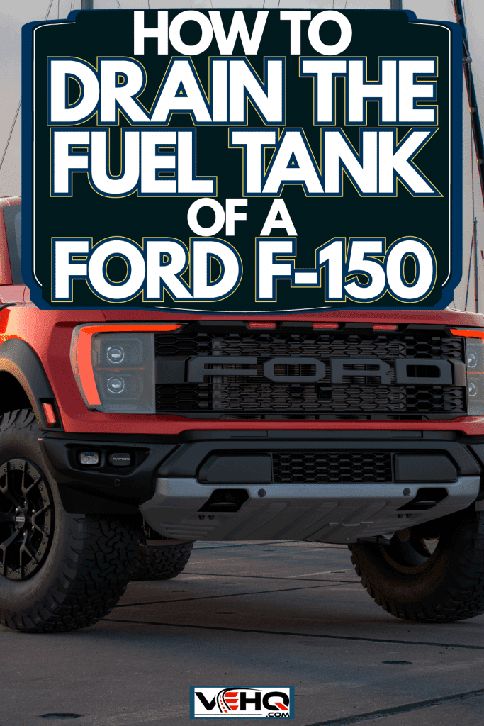 A big red colored Ford F-150 Raptor parked near a dock, How To Drain The Fuel Tank Of A Ford F-150