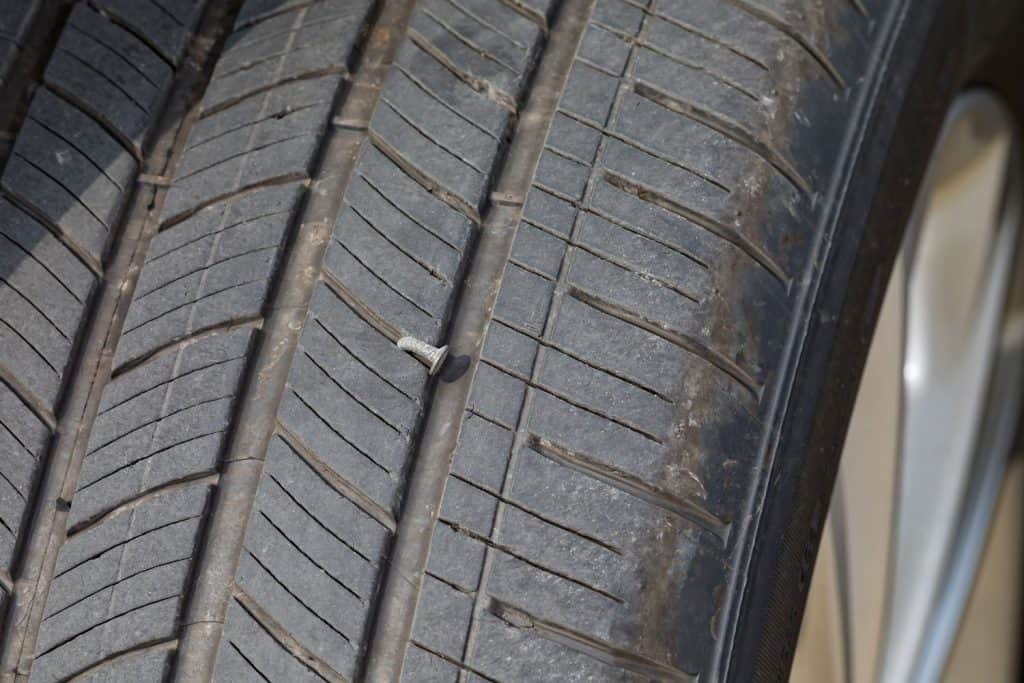 Nail in car tire. Concept of vehicle safety, flat tire, tire maintenance, repair and air pressure