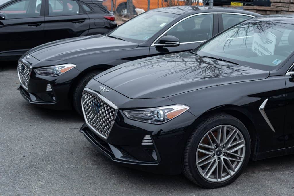 Two luxurious black Genesis G70 photographed at the dealership