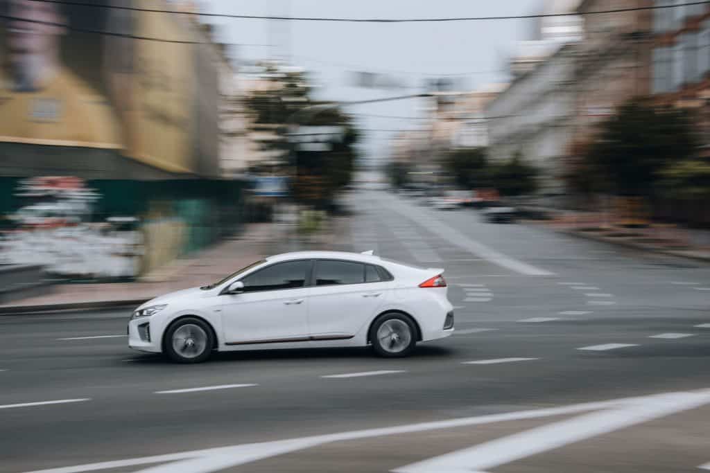 White Hyundai IONIQ car moving on the street