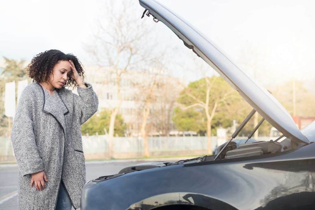 Woman after checking her car broken engine