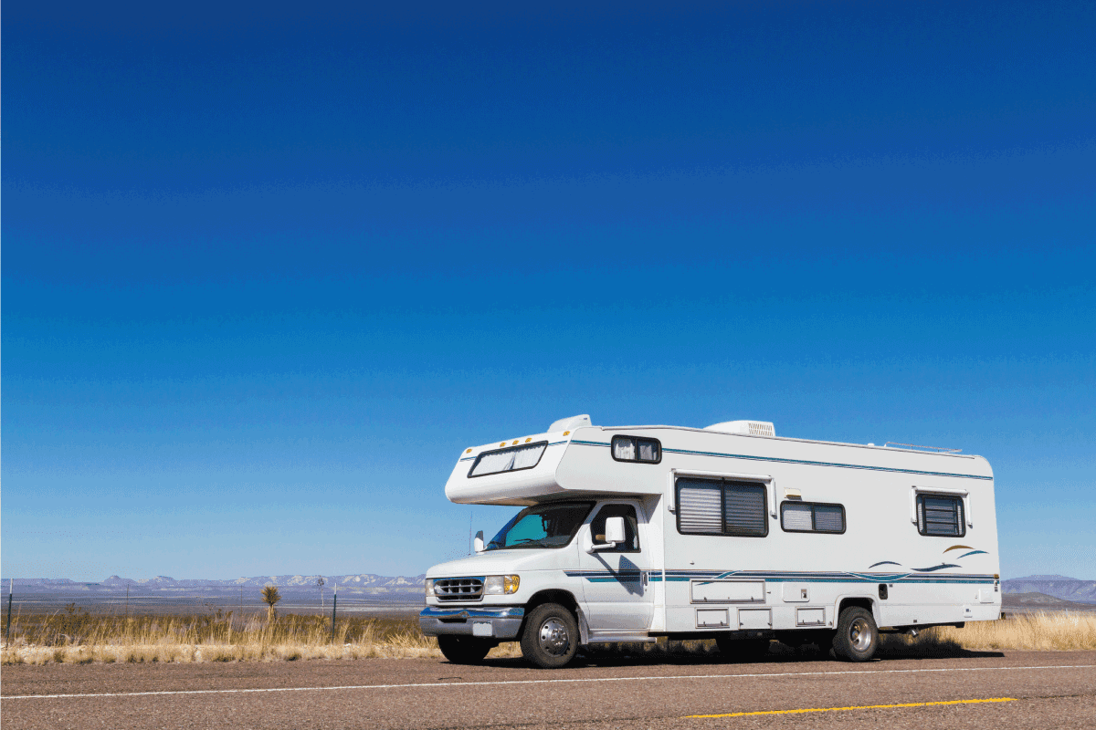 recreational vehicle motorhome parked on the side of a sunny road. How To Install Skirting Around RV (5 Simple Steps)