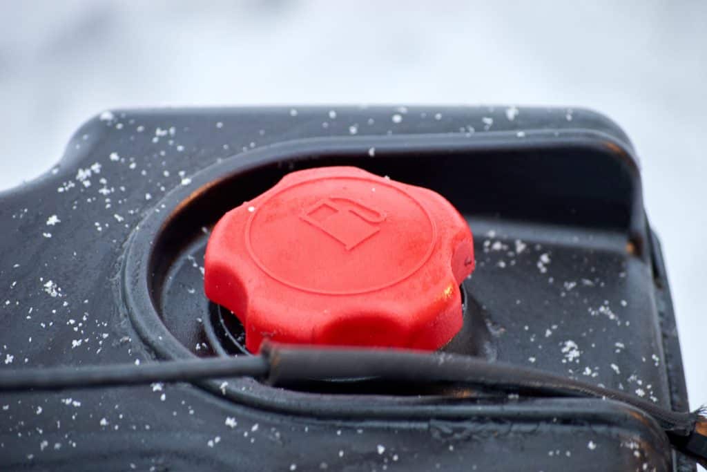 red cap of fuel tank with petrol symbol