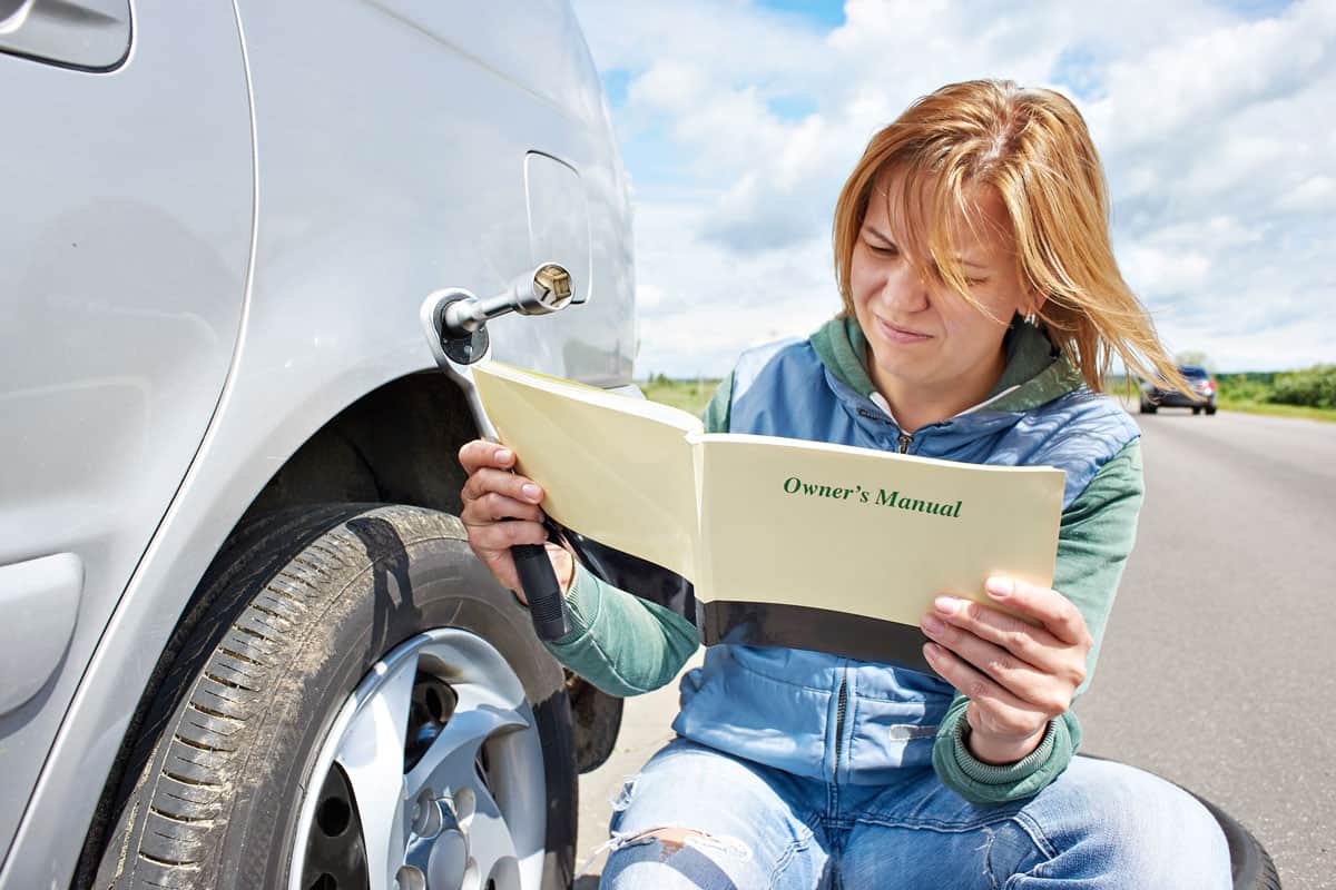 woman-reading-owners-manual-her-car