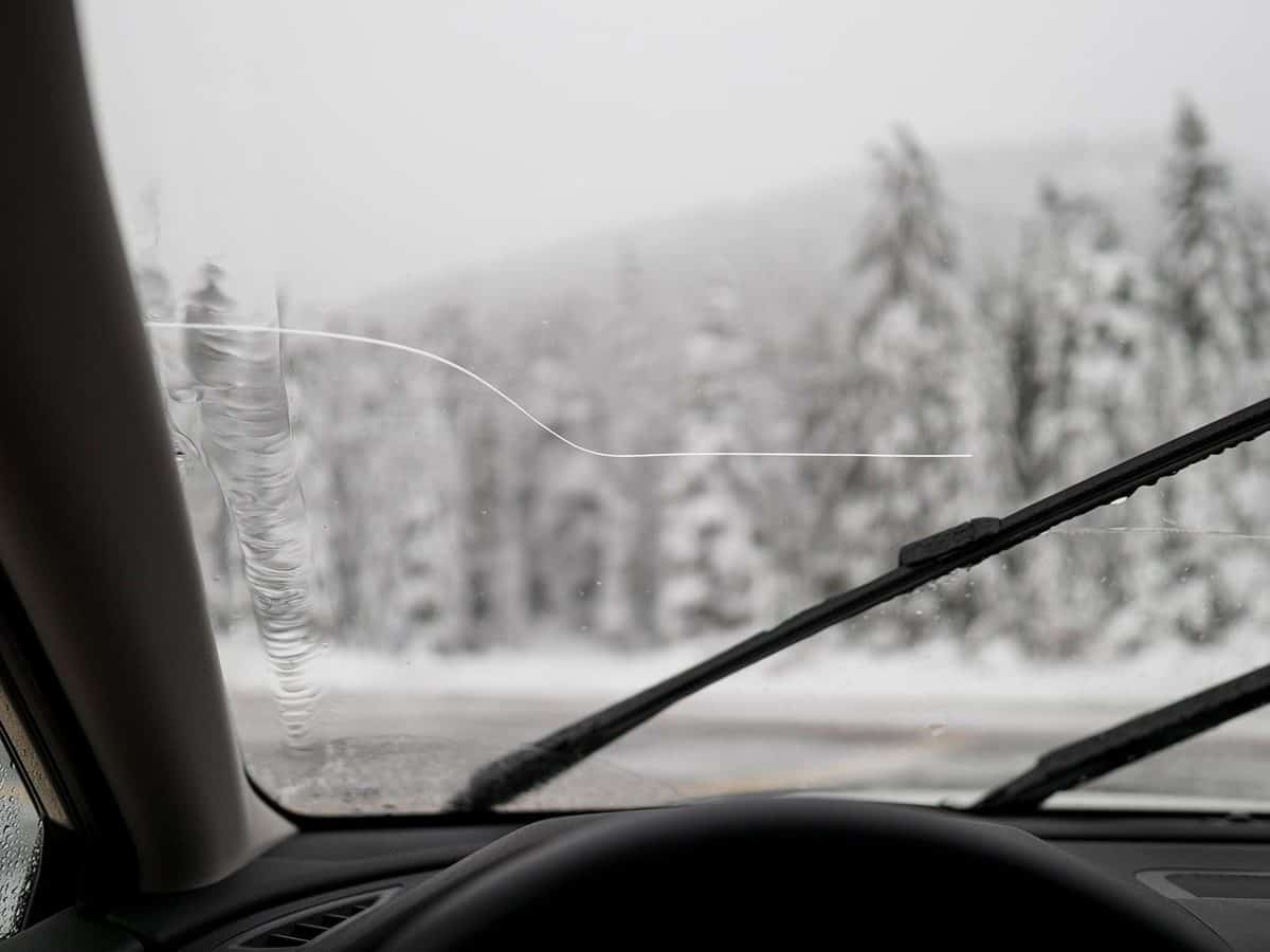 A POV view of a car windshield with large crack as seen from the passenger seat