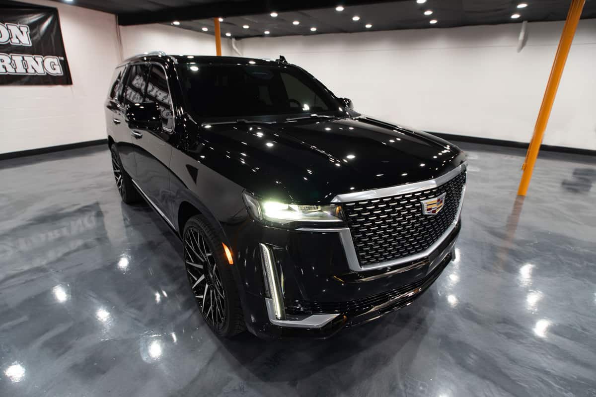 A black and shiny Cadillac Escalade photographed in a car show
