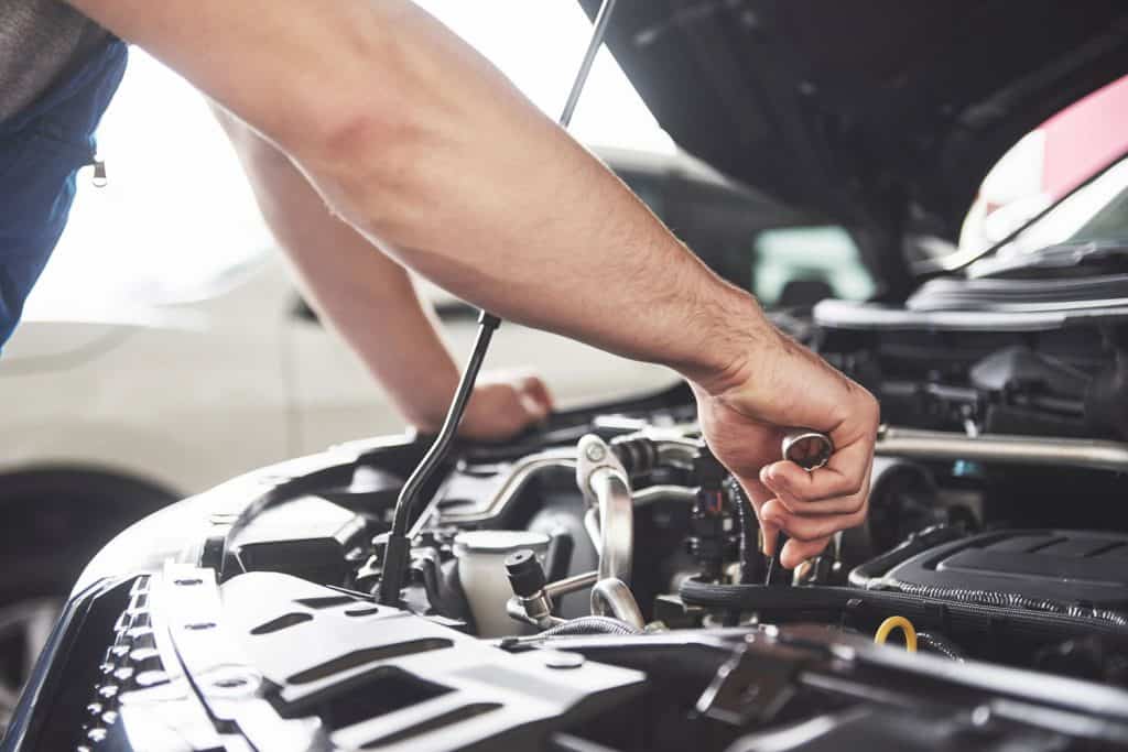 A car mechanic checking the car engine for faults