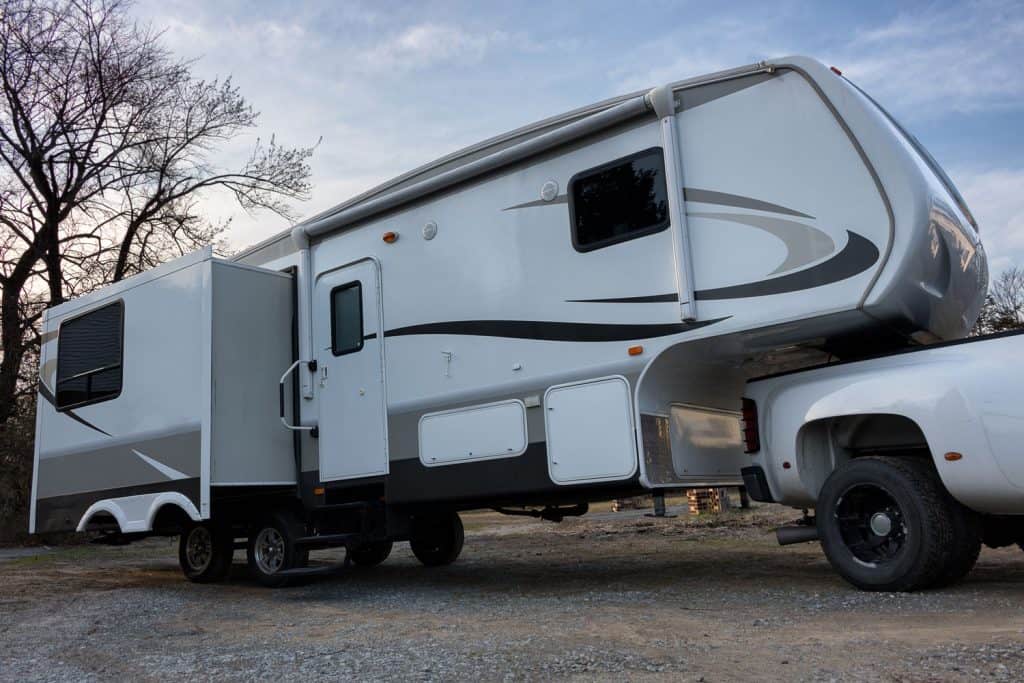 A fifth wheel trailer deployed in the camping grounds