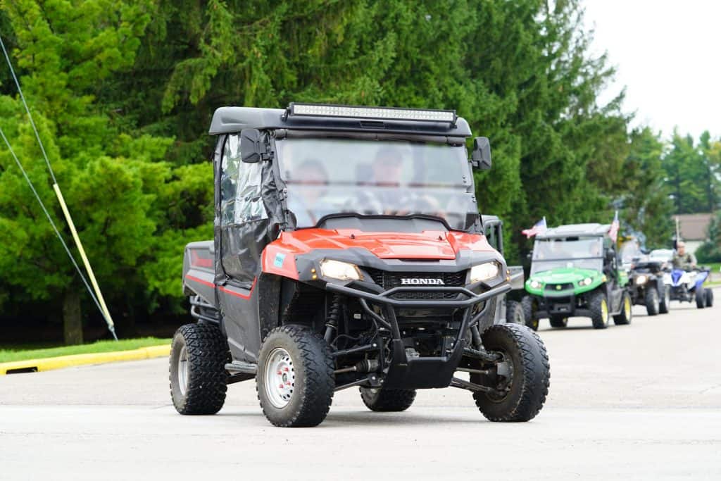 A red UTV moving on the camping ground