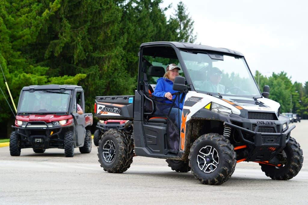 A sweet couple riding a UTV moving on the camping ground