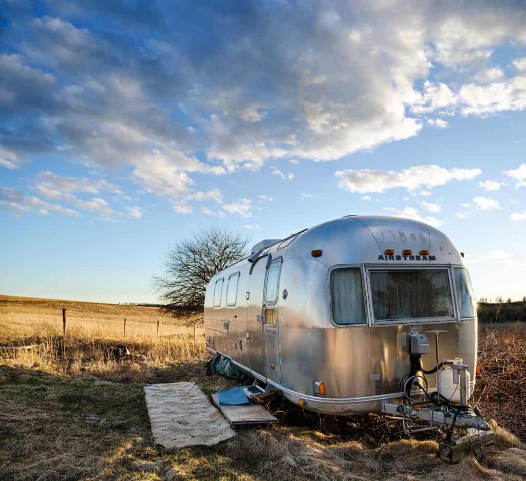 A well lived in Airstream International Overlander travel trailer parked in a field