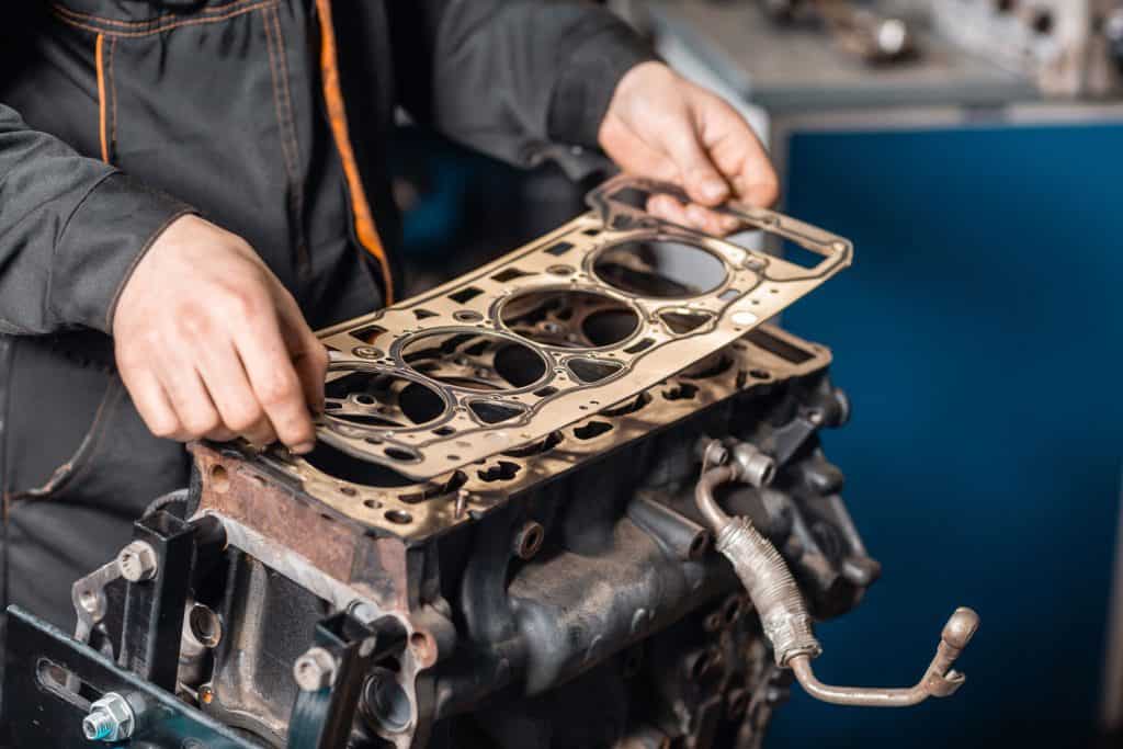 A worker removing the head gasket of the engine