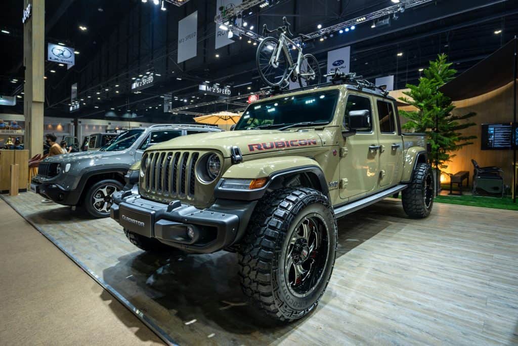 An army green Jeep Gladiator displayed at a car show