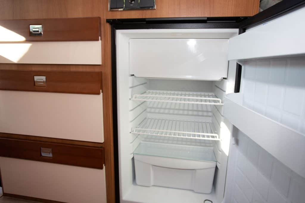 An empty RV refrigerator inside a luxury motorhome