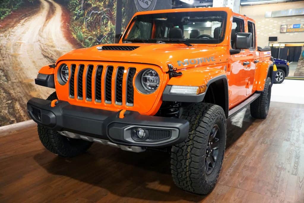 An orange colored Jeep Gladiator Rubicon displayed at a car show