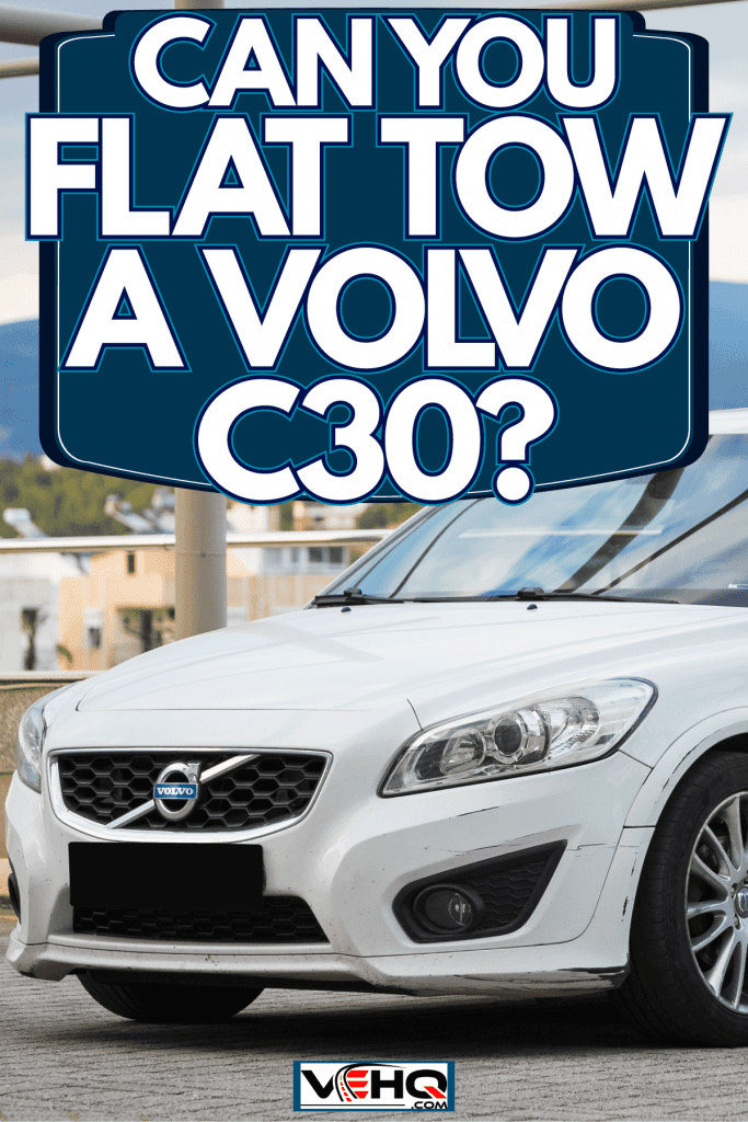 A white Volvo C30 parked on a rooftop parking area, Can You Flat Tow A Volvo C30?
