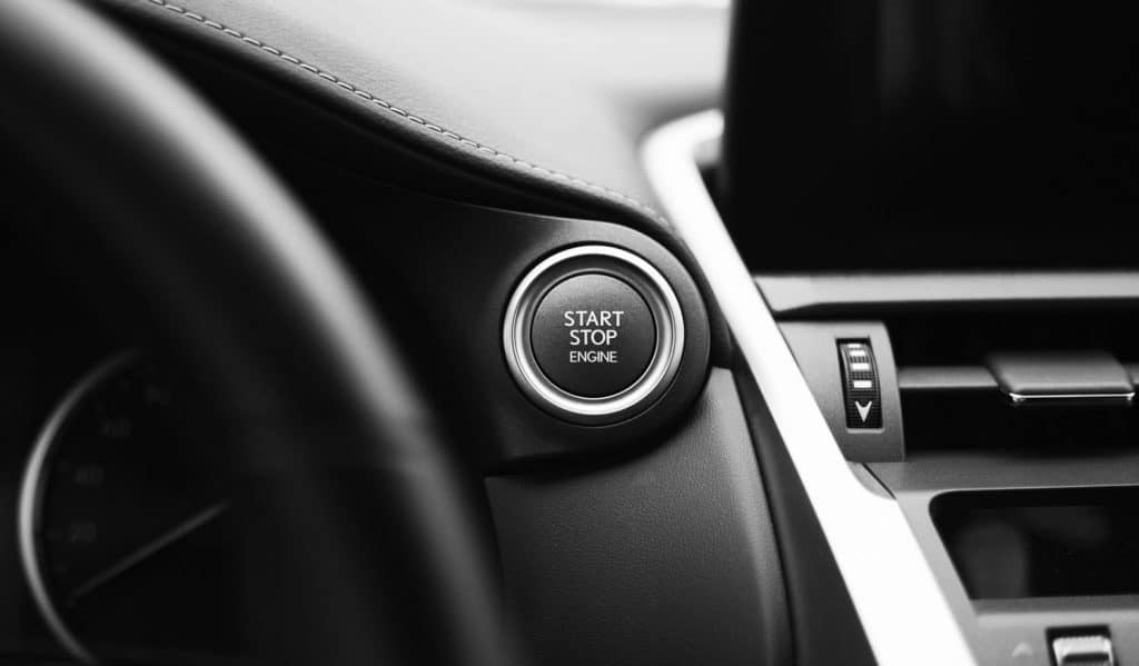Car engine start button black and white close-up with blurred background