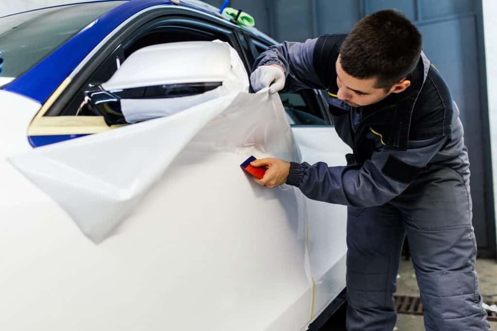 Car wrapping specialist putting vinyl foil or film on car