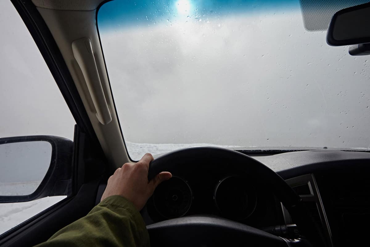 Close-up of the hands of the driver on the steering wheel of a car with fogged windshield, How To Defog Your Windshield Without Using The Heater