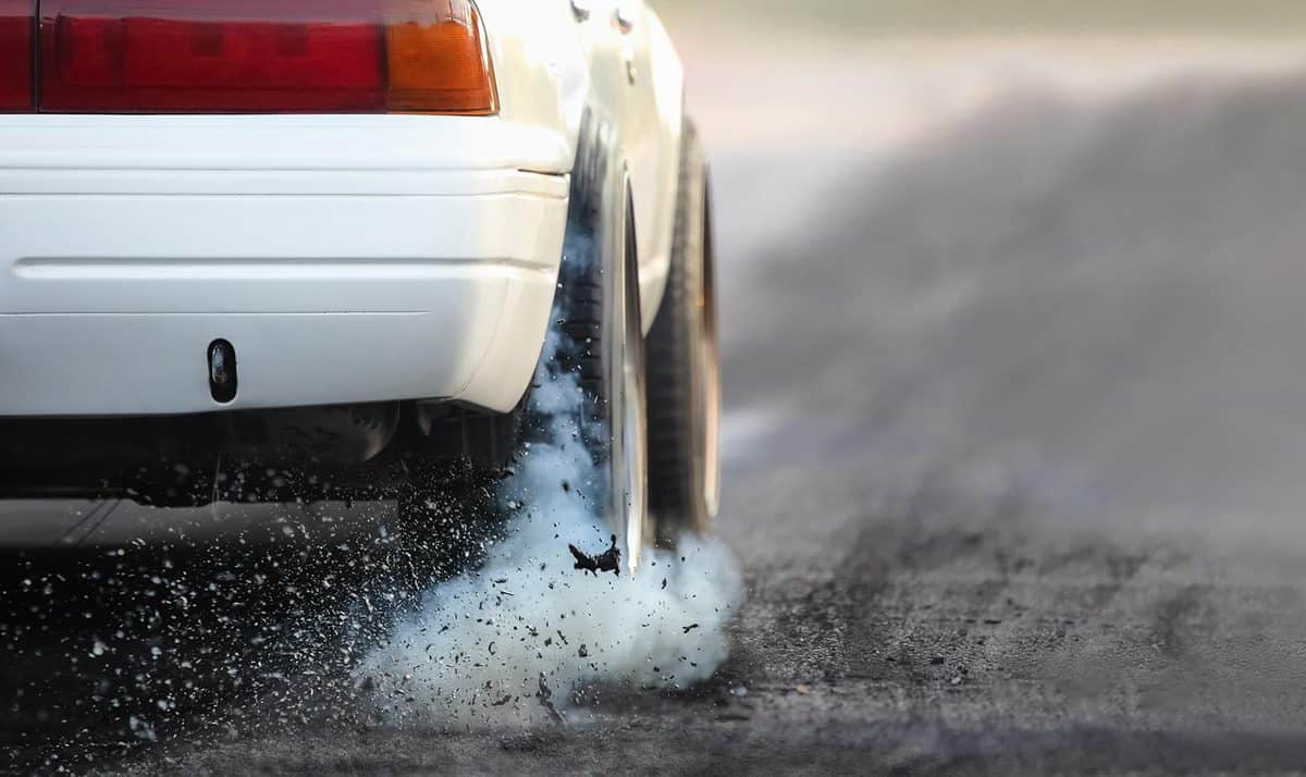 Drag racing car burns rubber off its tires