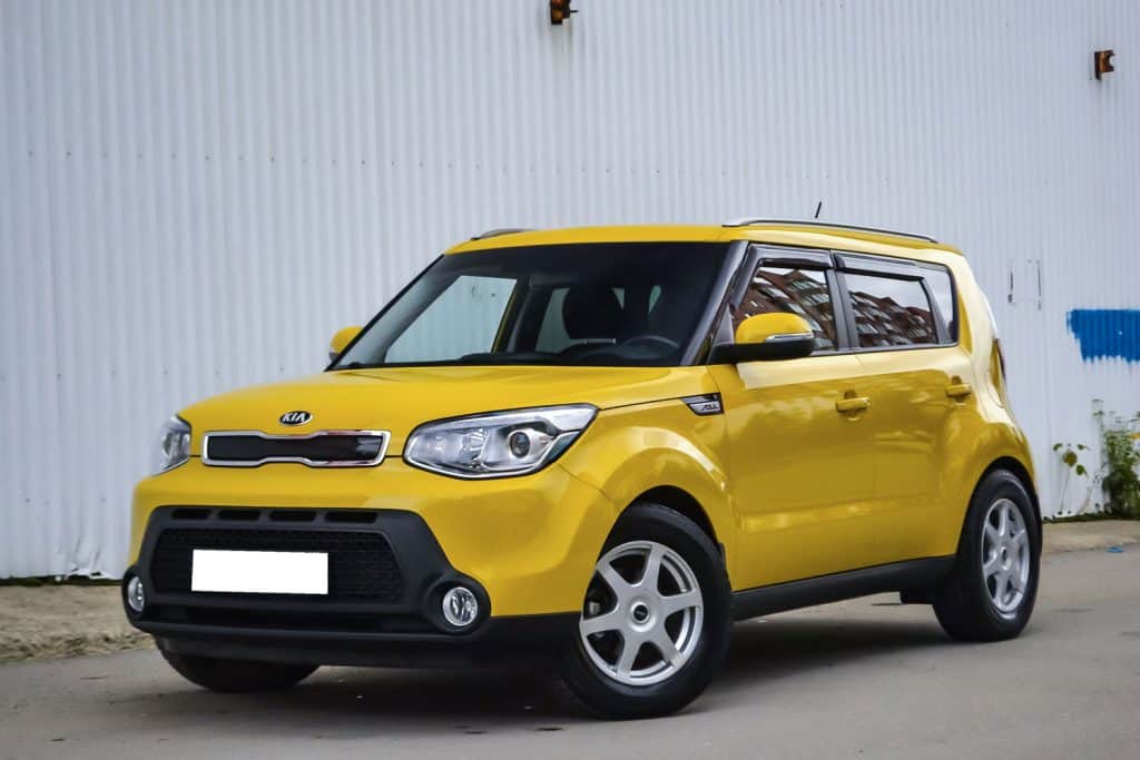 Front view of used Kia Soul in yellow color after cleaning before sale in a summer day