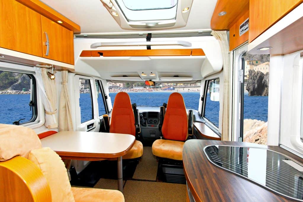 Interior of a rustic inspired RV motorhome with wooden shelves and countertops