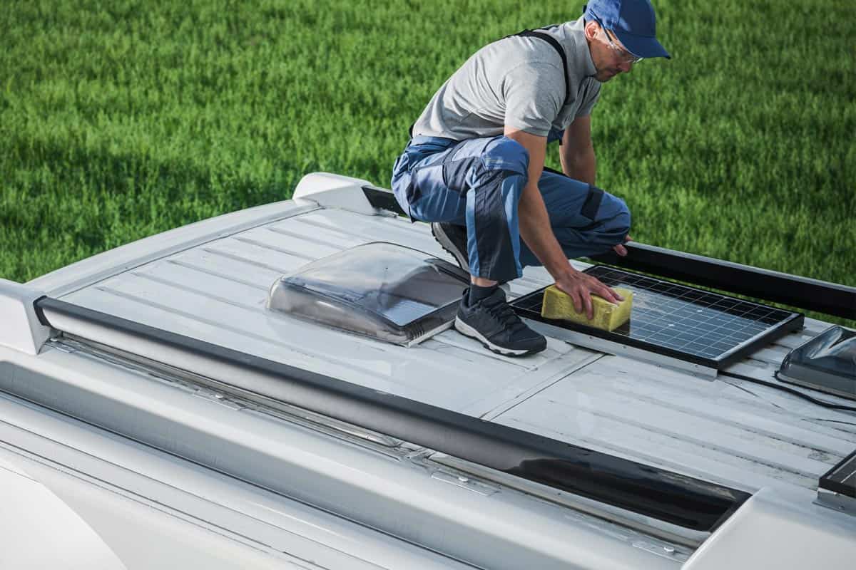 Man on top on an RV cleaning solar panels using sponge, Can You Walk On The Roof Of A Jayco RV?