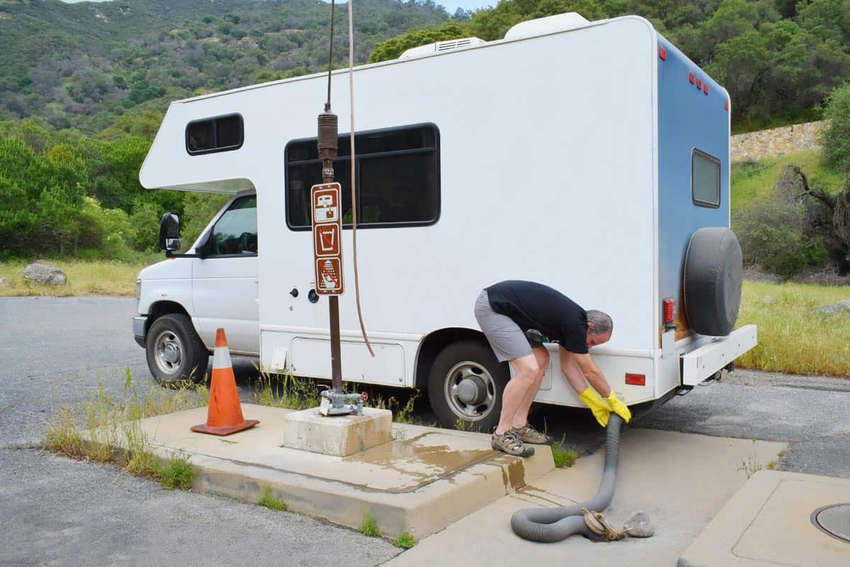Man serving RV in dumping station, How Does An RV Septic System Work?