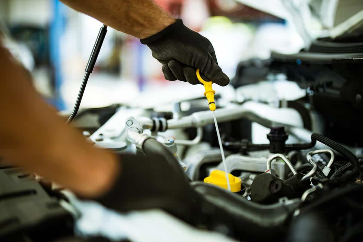 Mechanic examining car oil in a repair shop
