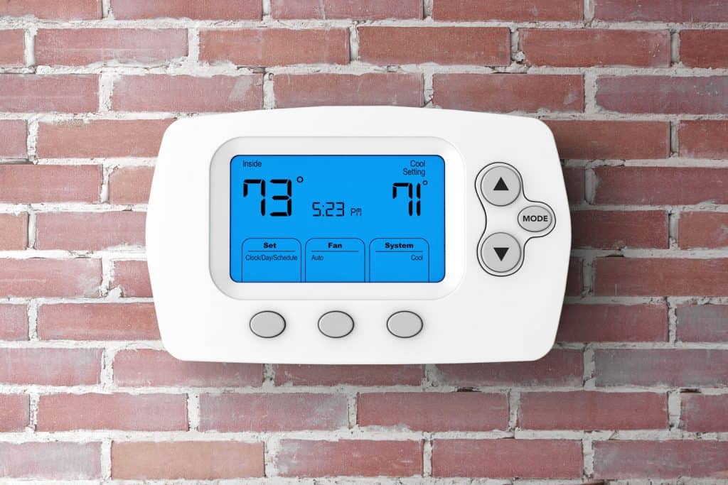 Modern Programming Thermostat in front of Brick Wall