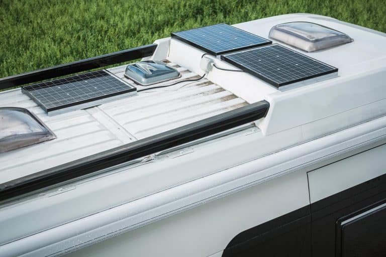 Parked camper van with three solar panels on top of the roof, Can You Paint A Rubber RV Roof? [And How To]
