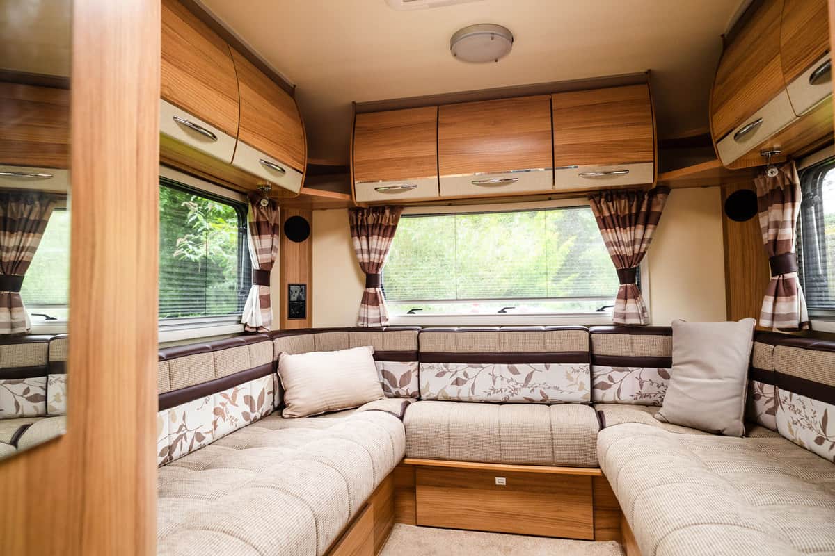 Wooden or rustic themed interior of an RV with gorgeous and comfy furniture's and brown curtains, How To Hang Heavy Things On Trailer Walls