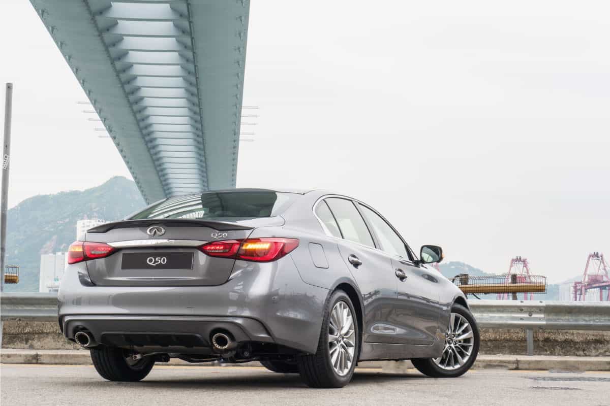 rear view of a silver colored Infiniti Q50 parked under a bridge. Does Infiniti Q50 Have Paddle Shifters
