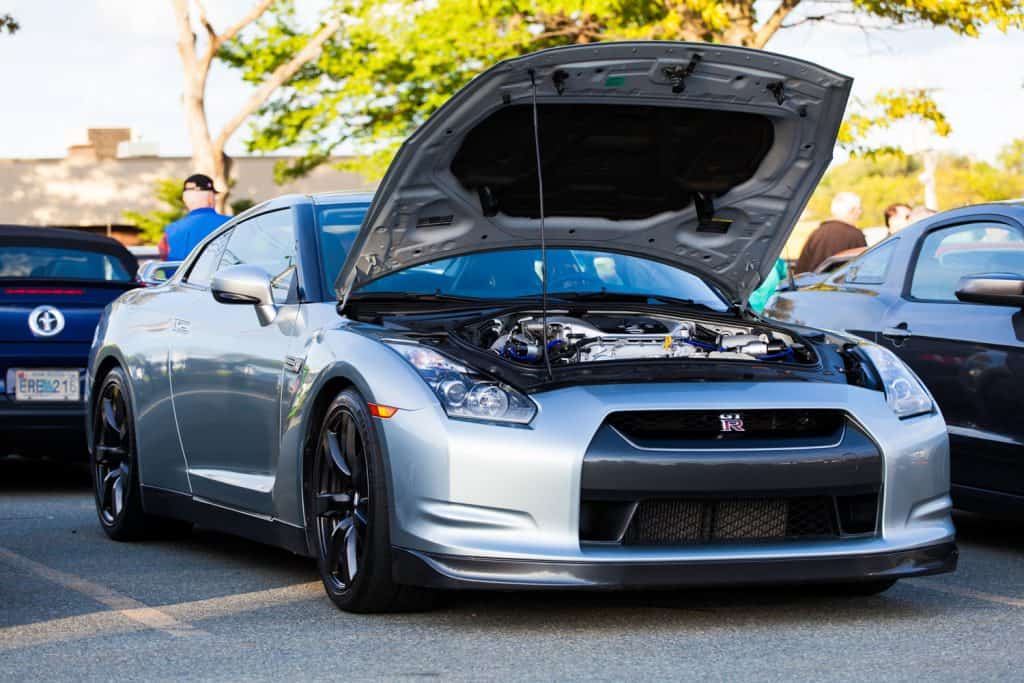 A Nissan GTR with the hood open showing the engine