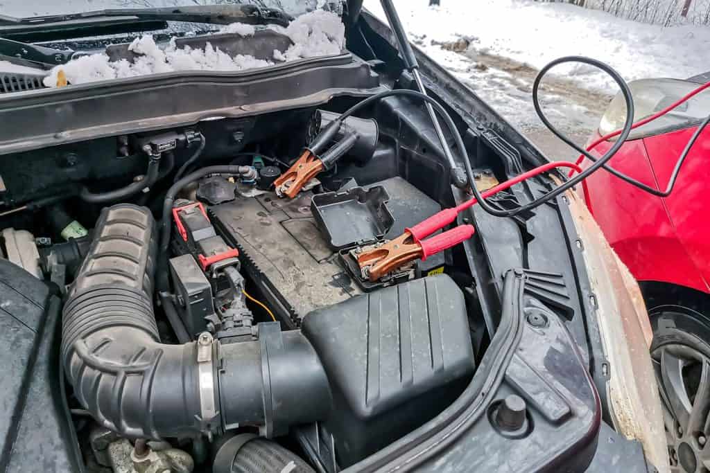 A car battery getting a jumpstart from another car