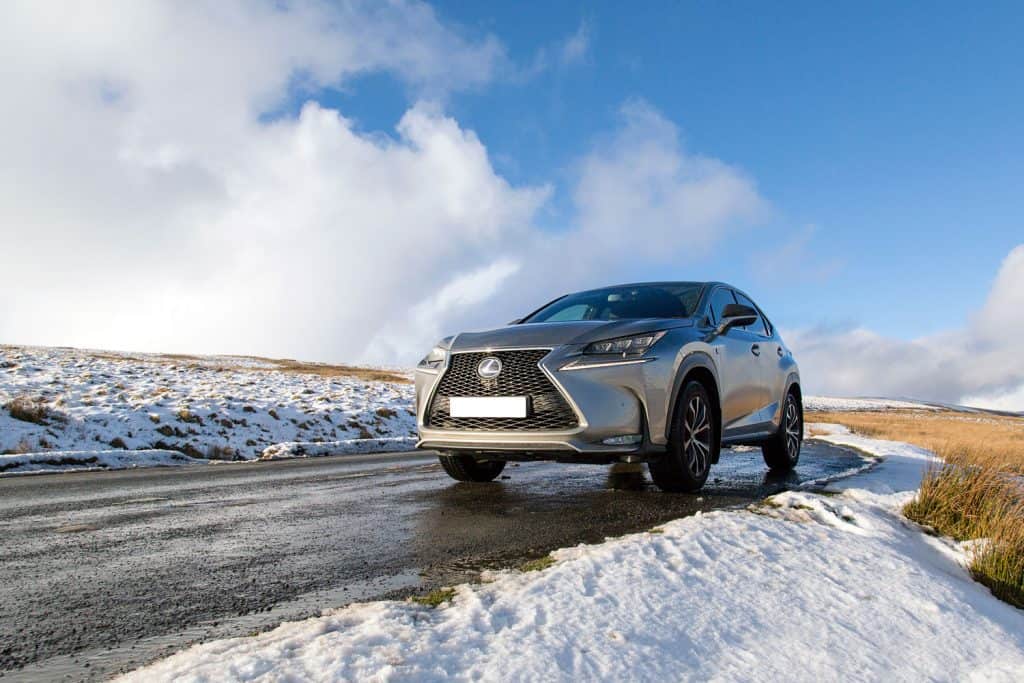 A gray Lexus NX300 moving on the snowy highway trail of the outback country