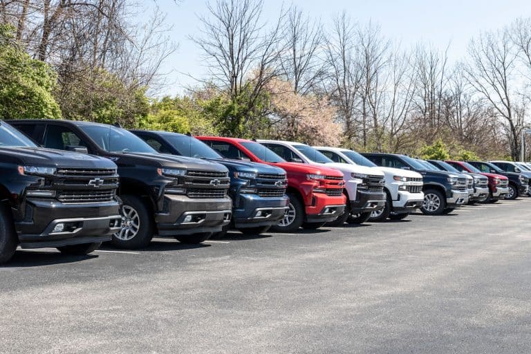 A line up of different trim levels of Chevrolet Suburban's and Silverado's at a dealership, How Long Is A Chevy Suburban? [Can It Fit In A Garage?]