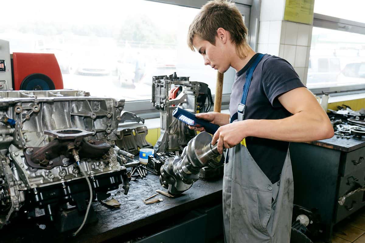 A vehicle mechanic is rebuilding an engine